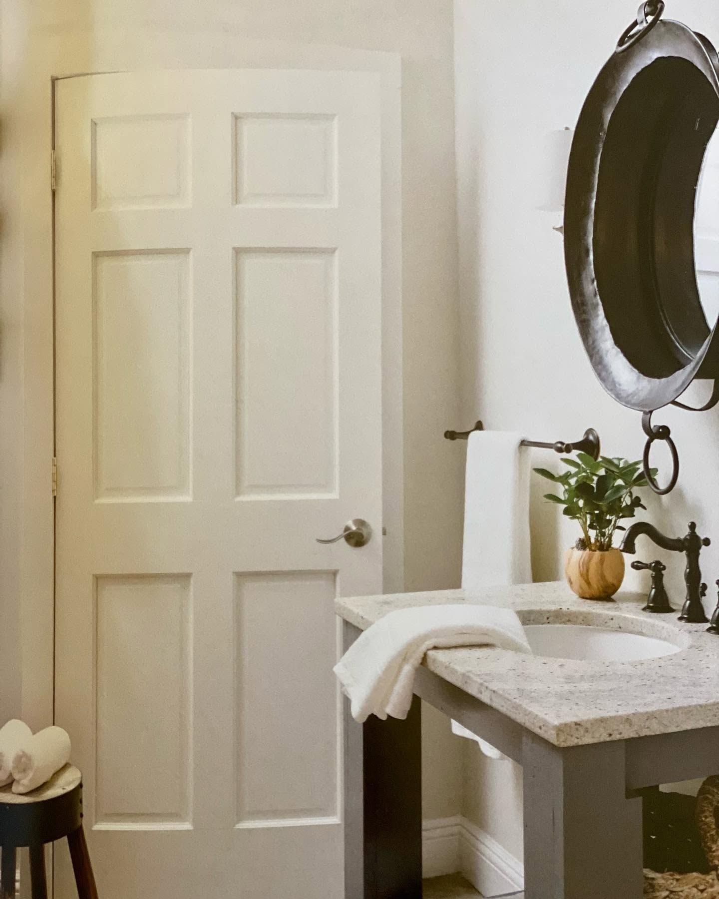 Bathroom with a hammered copper-pan mirror and a stone-topped vanity