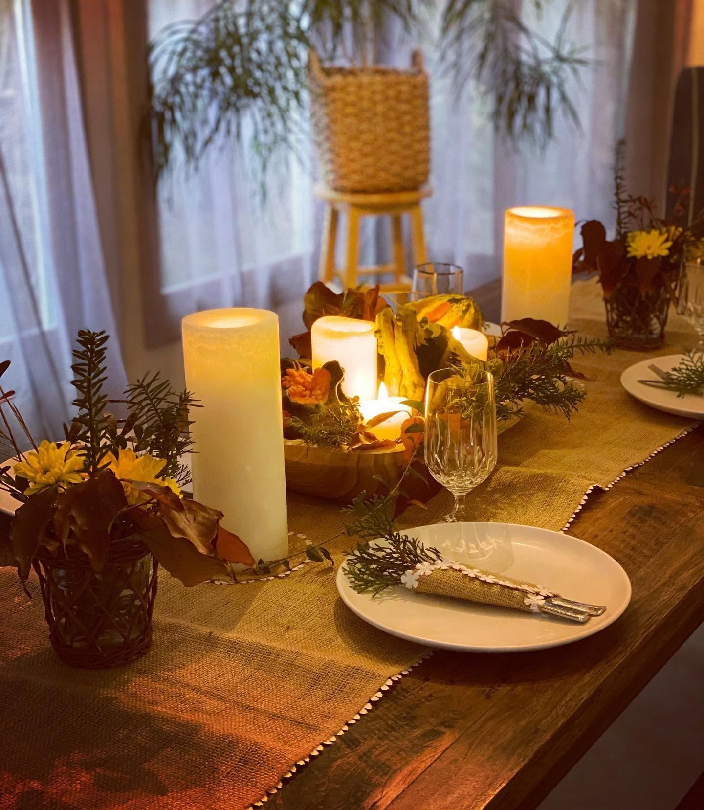 Autumn table set with burlap runner, candles and seasonal greenery